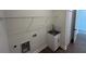 A quaint laundry room with sink and plenty of room for organizing with wire shelves at 493 E Palmetto Ave, Longwood, FL 32750