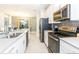 Contemporary kitchen with stainless steel appliances, white cabinetry, and an open view to the dining area at 4962 Windermere Ave, Kissimmee, FL 34746