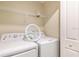Functional laundry area with a washer, dryer, and shelving for supplies at 4962 Windermere Ave, Kissimmee, FL 34746