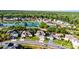 Aerial view of a residential neighborhood with a pond and tree-lined streets and well-maintained lawns at 5456 Crepe Myrtle Cir, Kissimmee, FL 34758