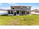 Spacious backyard with a well-maintained lawn and an enclosed sunroom at 5456 Crepe Myrtle Cir, Kissimmee, FL 34758