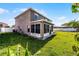 Property's backyard with an enclosed sunroom, a well-kept lawn, and a fenced perimeter at 5456 Crepe Myrtle Cir, Kissimmee, FL 34758