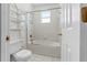 Compact bathroom featuring a bathtub with shower and white tiling at 5456 Crepe Myrtle Cir, Kissimmee, FL 34758