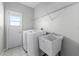 Bright laundry room with appliances, utility sink, and overhead shelving at 5456 Crepe Myrtle Cir, Kissimmee, FL 34758