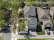 This is an aerial view of a beige two-story home with a brown roof and a brick driveway in a suburban neighborhood at 6475 New Independence Pkwy, Winter Garden, FL 34787