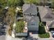 This is an aerial view of a beige two-story home with a brown roof and a brick driveway in a suburban neighborhood at 6475 New Independence Pkwy, Winter Garden, FL 34787