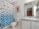 Well-lit bathroom with a white vanity and a shower with a patterned blue curtain at 6475 New Independence Pkwy, Winter Garden, FL 34787