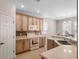 Functional kitchen features warm-toned cabinetry, white appliances, and ample countertop space at 6475 New Independence Pkwy, Winter Garden, FL 34787