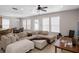 Spacious living room featuring a sectional sofa, tile floors, and natural light from multiple windows at 6475 New Independence Pkwy, Winter Garden, FL 34787
