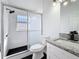 Bathroom featuring tile shower with sliding glass door, granite vanity and updated fixtures at 6921 Blair Dr, Orlando, FL 32818