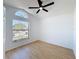 Bedroom featuring hardwood floors, a large arched window, and a ceiling fan at 6921 Blair Dr, Orlando, FL 32818