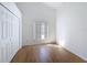 Bedroom featuring hardwood floors, a window with blinds and a closet for storage at 6921 Blair Dr, Orlando, FL 32818