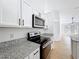 Well-appointed kitchen features stainless steel appliances, white cabinets, and granite countertops, bathed in natural light at 6921 Blair Dr, Orlando, FL 32818