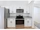 Modern kitchen with white cabinets, stainless steel appliances, and granite countertops offers a sleek design at 6921 Blair Dr, Orlando, FL 32818