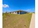 Backyard view featuring a green lawn and covered patio space at 992 Serchio St, Haines City, FL 33844