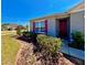 Charming single-story home featuring a red front door, tidy landscaping, and a well-manicured lawn at 992 Serchio St, Haines City, FL 33844