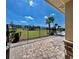 Community playground area with a black metal fence, lush green grass, and tropical palm trees at 992 Serchio St, Haines City, FL 33844
