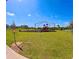 Community playground area with colorful play equipment and a lush green field for children to enjoy at 992 Serchio St, Haines City, FL 33844