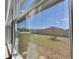Window view of private fenced backyard with green grass and young trees at 992 Serchio St, Haines City, FL 33844