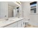 Bright bathroom with double vanity, large mirror, tile floor, and glass-doored shower at 10372 Austrina Oak Loop, Winter Garden, FL 34787