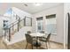 Bright dining area with modern table, staircase, and natural light from large windows at 10372 Austrina Oak Loop, Winter Garden, FL 34787