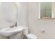 Bright half bathroom featuring a pedestal sink, modern toilet, and decorative accents at 10372 Austrina Oak Loop, Winter Garden, FL 34787