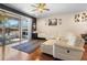 Inviting living room with a white leather sectional sofa, fan, and sliding glass doors to the outdoor patio at 10785 Corsican St # 3, Orlando, FL 32824