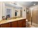 Well-lit bathroom featuring double sinks, granite countertops, and a glass shower at 10785 Corsican St # 3, Orlando, FL 32824