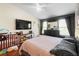 Bright main bedroom with a ceiling fan, television and a crib at 10785 Corsican St # 3, Orlando, FL 32824