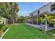 An outdoor space featuring a screened patio, green lawn, mature trees, and a grilling area at 122 Carmel Bay Dr, Sanford, FL 32771