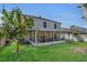 A backyard view of a two-story home with a screened patio and lush green lawn at 122 Carmel Bay Dr, Sanford, FL 32771