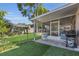 Charming backyard with a screened-in porch, lush lawn, and mature landscaping at 122 Carmel Bay Dr, Sanford, FL 32771