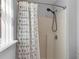 Bathroom features a shower with leaf-patterned curtain and chrome shower head at 122 Carmel Bay Dr, Sanford, FL 32771