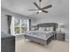 Elegant bedroom featuring a ceiling fan, large window, and glamorous, tufted furniture at 122 Carmel Bay Dr, Sanford, FL 32771