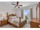 Cozy bedroom featuring a ceiling fan, natural light, soft bedding, and classic wood furniture at 122 Carmel Bay Dr, Sanford, FL 32771