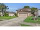 Two-story home has a two car garage with green grass and a mature palm tree at 122 Carmel Bay Dr, Sanford, FL 32771