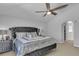 Stylish bedroom with gray furniture, ceiling fan, and view to the closet through the arched door at 122 Carmel Bay Dr, Sanford, FL 32771