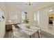 Formal dining room featuring a sleek marble table, bright neutral decor, and an adjacent pass-through to the kitchen at 13850 Mirror Lake Dr, Orlando, FL 32828