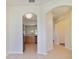 Hallway with archways, leading to kitchen with stainless steel appliances at 13850 Mirror Lake Dr, Orlando, FL 32828