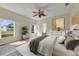 Spacious main bedroom with plantation shutters, a ceiling fan, and bright decor with a view of the backyard at 13850 Mirror Lake Dr, Orlando, FL 32828