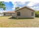 Back exterior view, light colored house with lush green grass and landscaping at 1456 Providence Blvd, Deltona, FL 32725