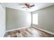 Cozy bedroom with wood-look floors, ceiling fan, and natural light from the window at 1456 Providence Blvd, Deltona, FL 32725