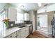 Well-lit kitchen with white cabinetry, grey subway tile backsplash, and a stainless steel sink at 1456 Providence Blvd, Deltona, FL 32725