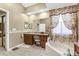 Bright bathroom features a garden tub and vanity with granite countertop, complemented by tile flooring at 158 Cedar Springs Cir, Debary, FL 32713