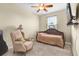 Cozy bedroom features a chair, ceiling fan, and warm neutral walls, creating a comforting and inviting space at 158 Cedar Springs Cir, Debary, FL 32713