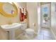 Clean powder room featuring a stylish pedestal sink, gold fixtures, and a door with natural light at 1649 Kersley Cir, Lake Mary, FL 32746