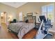 Bright bedroom featuring hardwood floors, a workstation and exercise equipment, plus lots of natural light from the large windows at 1649 Kersley Cir, Lake Mary, FL 32746