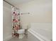 Functional bathroom featuring a shower with a patterned curtain and a tiled soaking tub at 1740 Efland Ter, Deltona, FL 32738