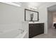 Bathroom features soaking tub, dark wood vanity, and a large mirror at 1740 Efland Ter, Deltona, FL 32738