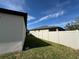 View of backyard featuring well-maintained lawn and white vinyl fencing for privacy, enhancing outdoor enjoyment at 1825 Cayman Cove Cir, St Cloud, FL 34772